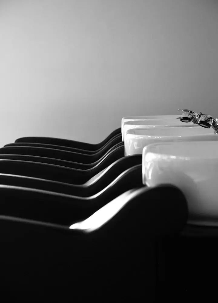 Modern hair salon washing station with black chairs